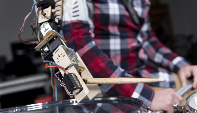 Gil Weinberg with Tyler White playing drums with a robotic arm